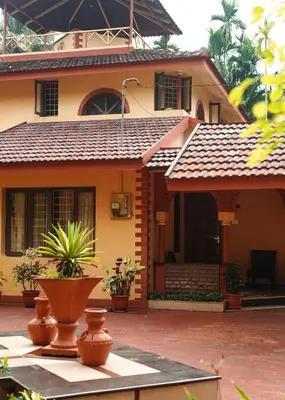 a house with a roof with plants in front of it at Boughn Villa in Kozhikode
