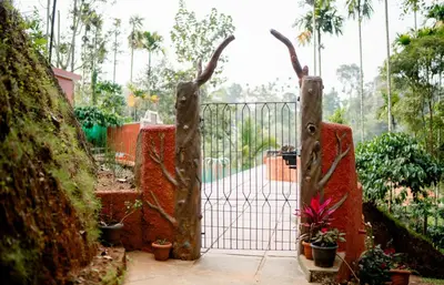 an iron gate with antlers in a garden at Beehive staycations in Ambalavayal