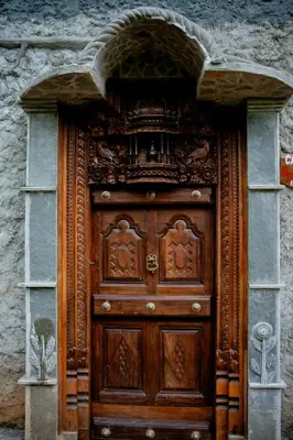 a large wooden door in a stone building at Beehive staycations in Ambalavayal