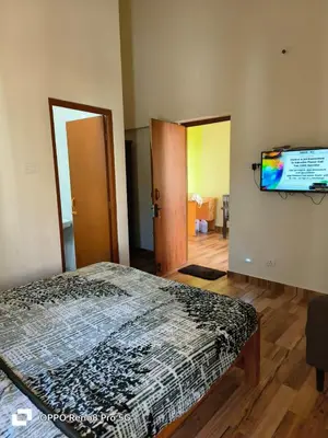 a bedroom with a bed and a flat screen tv at Dwarka Home Stay in Ooty