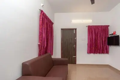 a living room with a couch and red curtains at Hotel Varun 1 bhk in Coimbatore