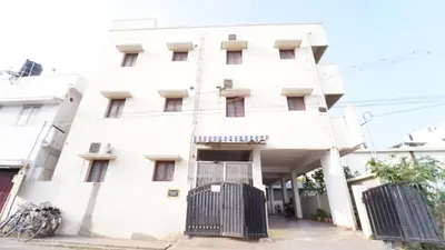 a white building with a gate in front of it at Hotel Varun 1 bhk in Coimbatore