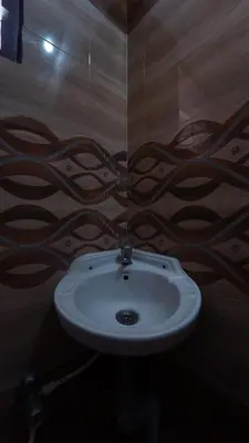 a bathroom with a white sink in a room at Hotel Varun 1 bhk in Coimbatore