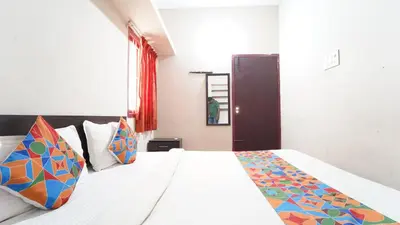 a bedroom with a white bed with colorful pillows at Hotel Varun 1 bhk in Coimbatore
