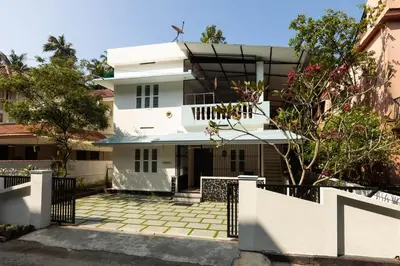 a white house with a fence in front of it at Chitralayam Home stay in Guruvāyūr
