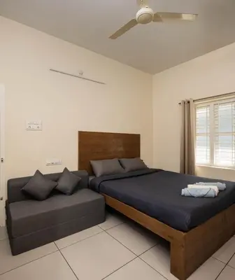 a bedroom with two beds and a couch at Chitralayam Home stay in Guruvāyūr