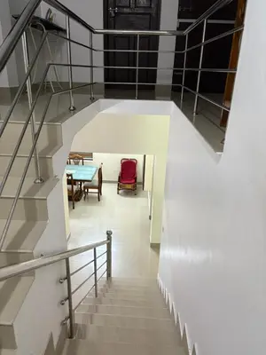 a staircase with a table and a dining room at Moms Villa in Nedumbassery