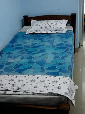 a bed with a blue blanket and pillows on it at Beautiful and Peaceful house in Kanjikode