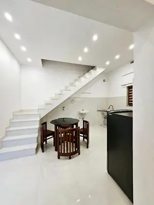 a kitchen and dining room with a table and stairs at Mariya Home Stay in Kanjikode