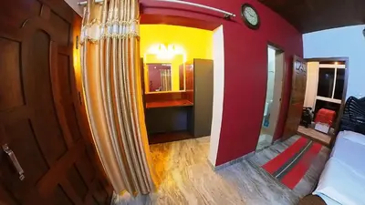 a room with a bed and a clock on the wall at Homestay Rooms Muzhakkunnu Near Kannur International Airport in Iritti