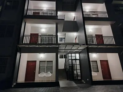 a four story building with three floors and three balconies at Wild Wind Resort in Batheri