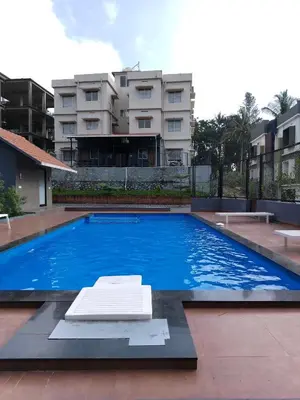 a large swimming pool in front of a building at Wild Wind Resort in Batheri