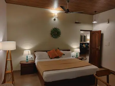 a bedroom with a bed with two lamps and a couch at The Elegant homes in Kushālnagar