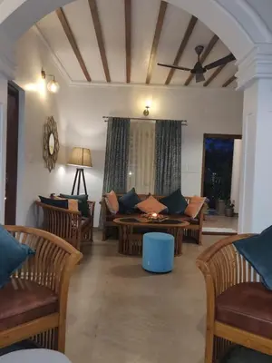 a living room with couches and a table at The Elegant homes in Kushālnagar