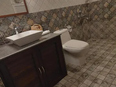 a bathroom with a toilet and a sink at The Elegant homes in Kushālnagar