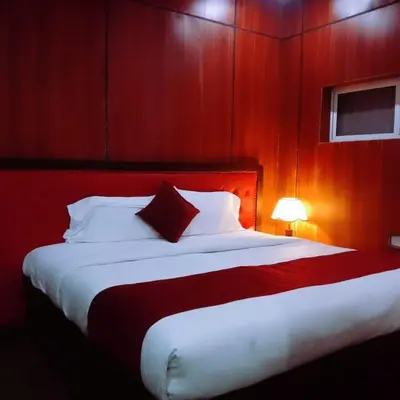 a bedroom with a large bed with a red wall at Ghala Residency in Munnar