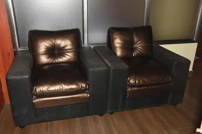 two brown leather chairs sitting next to each other at Ghala Residency in Munnar