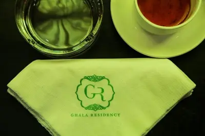 a table topped with a napkin with a cup of coffee at Ghala Residency in Munnar