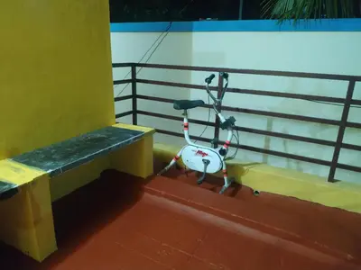 a bike parked next to a bench on a boat at Mithu's Nest-Ur Holiday Abode in Coimbatore