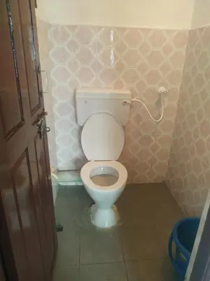 a bathroom with a toilet in a small room at Mithu's Nest-Ur Holiday Abode in Coimbatore