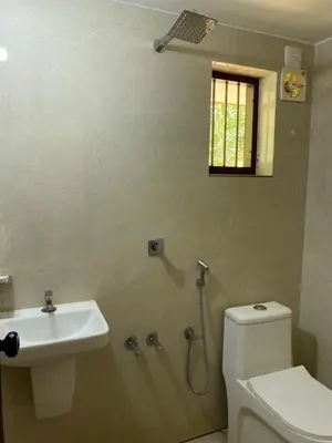 a bathroom with a toilet and a sink and a window at Gaya beach hacienda in Irimbranallūr
