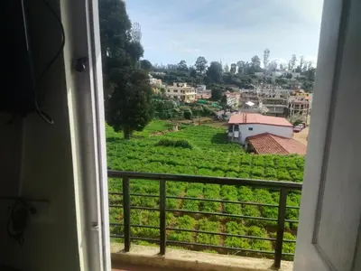 a view from a window of a village at Ooty mountain cottage in Ooty