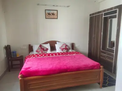 a bedroom with a wooden bed with a pink blanket at Ooty mountain cottage in Ooty