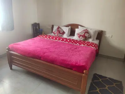 a bed with a pink blanket and pillows on it at Ooty mountain cottage in Ooty