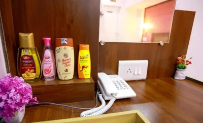a room with a phone and some bottles on a table at Base9 Family Lounge -Cochin Airport in Nedumbassery