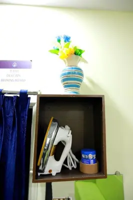 a wooden shelf with a vase on top of it at Base9 Family Lounge -Cochin Airport in Nedumbassery