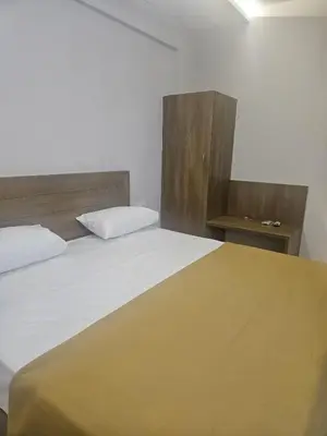 a bedroom with a large bed with a wooden headboard at Regent Tourist Home in Palakkad