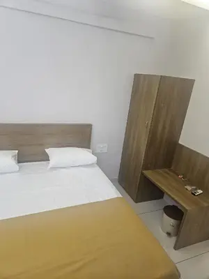a bedroom with a bed and a wooden table at Regent Tourist Home in Palakkad