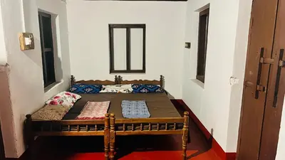 a small bedroom with a bed in a room at Tharavadu Homestay in Athirappilly