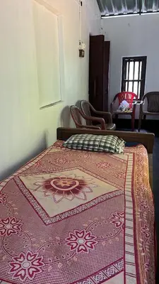 a bedroom with a bed with a red blanket on it at Tharavadu Homestay in Athirappilly