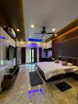 a bedroom with a large bed and a television at Kings Villa Mysore in Mysore