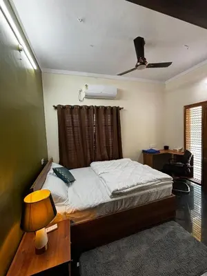 a bedroom with a bed with a ceiling fan at Kings Villa Mysore in Mysore