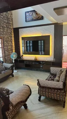 a living room with couches and a flat screen tv at Kings Villa Mysore in Mysore