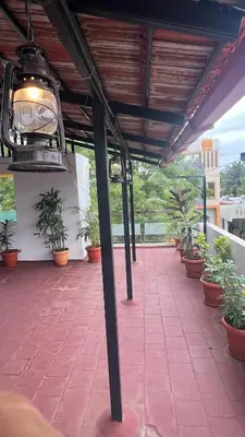 a patio with potted plants on a balcony at Kings Villa Mysore in Mysore