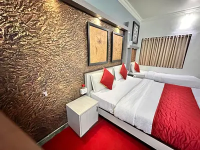 a bedroom with a large bed and a red carpet at City Palace Hotel in Ooty