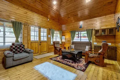 a living room with wooden walls and wooden floors at StayVista at The Woodscapes with Lawn & Views in Ooty