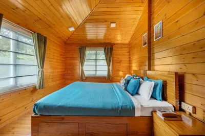 a bedroom with a bed in a wooden room at StayVista at The Woodscapes with Lawn & Views in Ooty