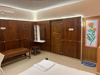 a bedroom with wooden walls and a bed and a bench at Mountain Breeze Resort Vattavada in Munnar