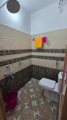 a bathroom with a toilet and a tiled floor at Mountain Breeze Resort Vattavada in Munnar