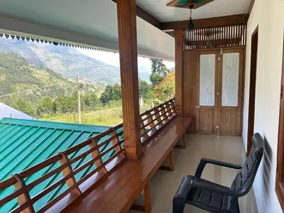 a balcony with a chair and a view of a mountain at Mountain Breeze Resort Vattavada in Munnar