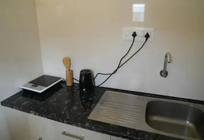a kitchen counter with a sink and a phone at Perfect getaway in Mysore
