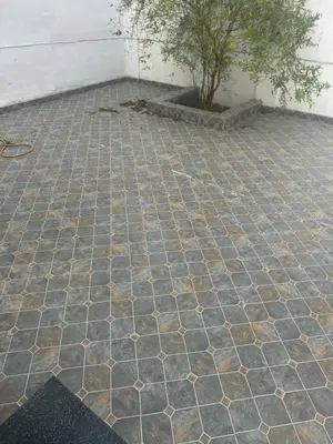 a stone patio with a tree in the background at Perfect getaway in Mysore