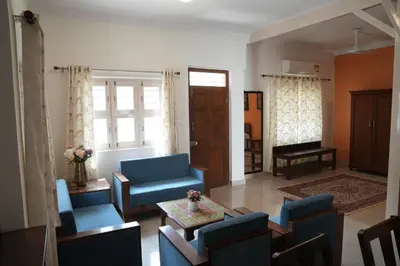 a living room with blue chairs and a table at Perfect getaway in Mysore