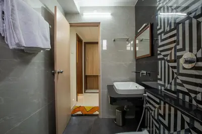a bathroom with a sink and a toilet at Hotel PRM Aruna Archadia in Erode