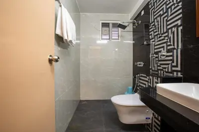 a bathroom with a toilet and a sink and a shower at Hotel PRM Aruna Archadia in Erode