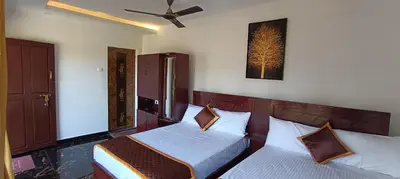 a bedroom with two beds and a picture on the wall at Glasshouse Retreat by The Jungle stay groups in Vālpārai